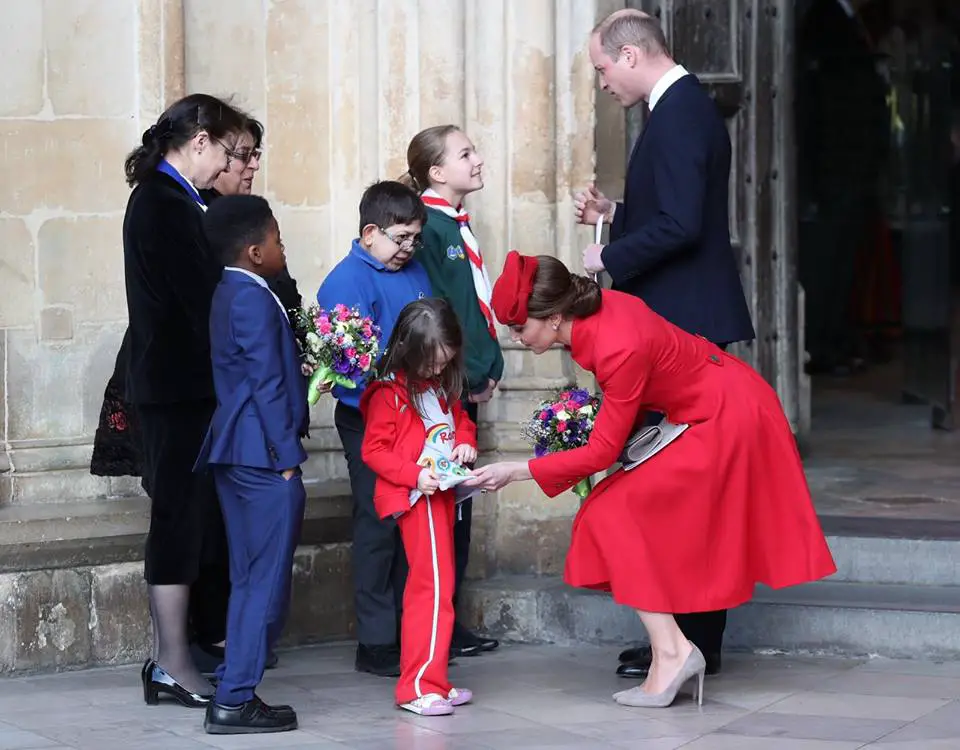 The Duchess of Cambridge was presented with the flowers at the Abbey then she checks out the young Rainbow's badges on the shirt of the children at the Commonwealth Day Service.